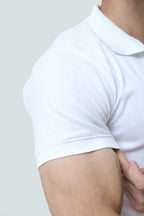 White cable-knit polo shirt from theseventhstitch with a classic collar and textured knit design, displayed on a flat surface.